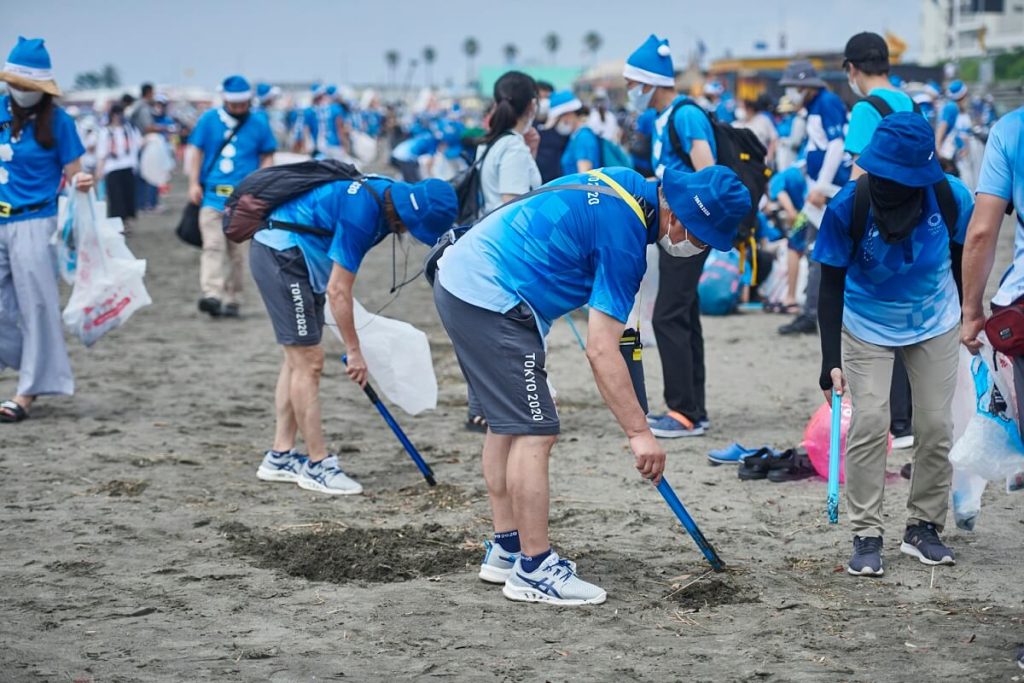 沢山のボランティアたちが海岸のゴミ拾いを行う様子の写真