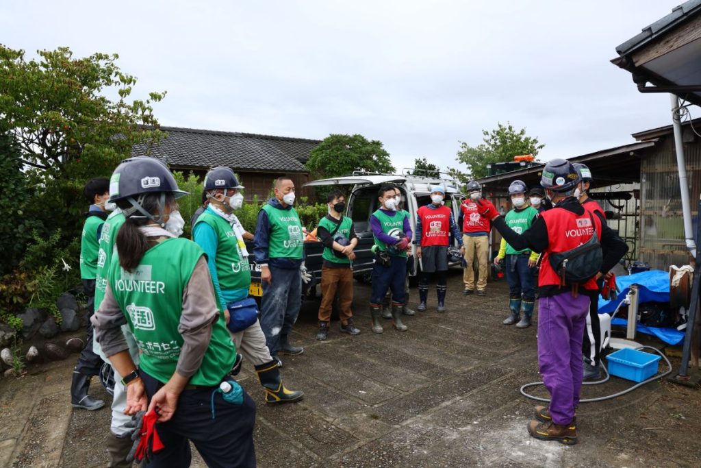 災害ボランティア活動を行う前に、ボランティアが集まり、心得や注意点について共有する様子の写真