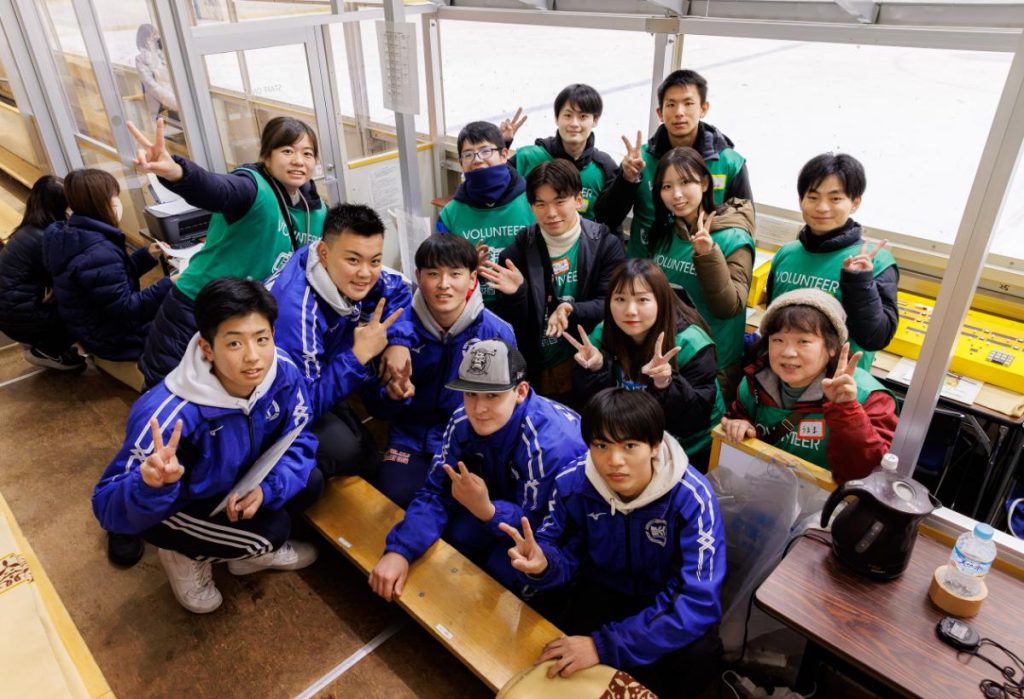 アイスホッケーの試合の後、オフィシャルエリア内で記念撮影をする軽井沢高校のアイスホッケー部員とボランティアたちの様子