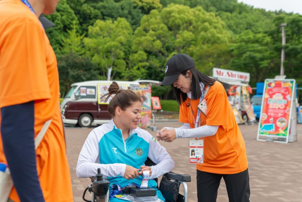 会場内で出場選手と交流するボランティア