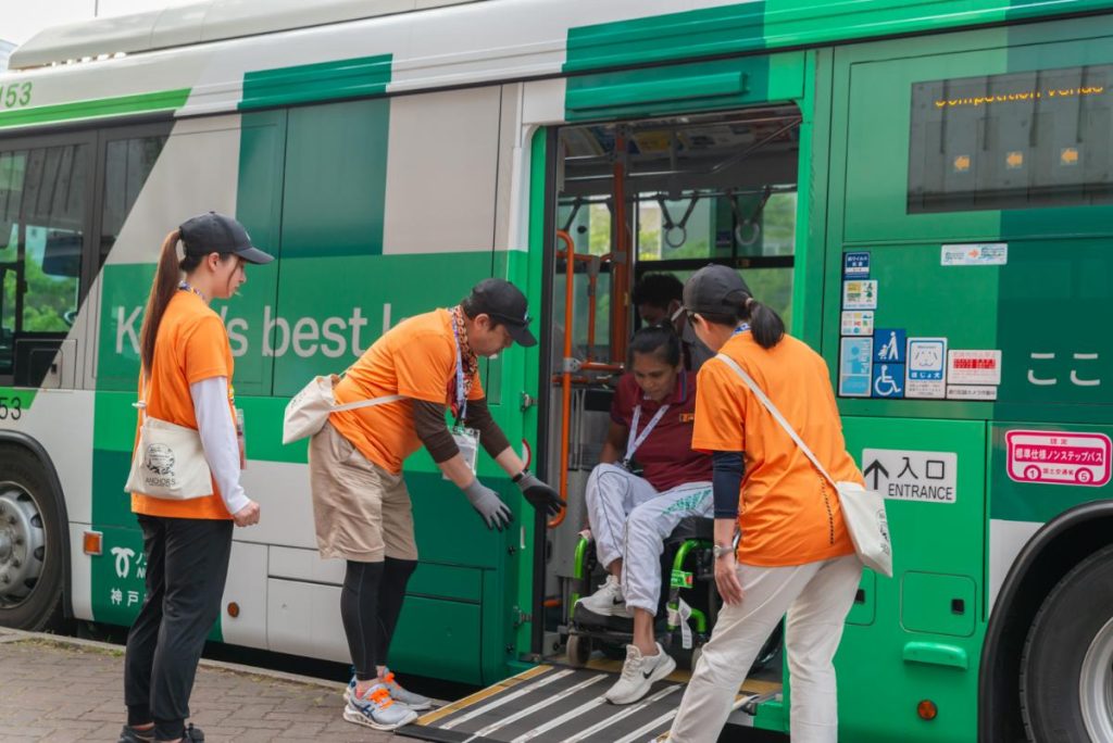 車椅子の選手の降車をサポートするボランティア