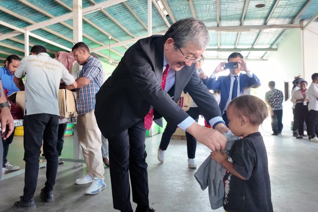 山脇会長が寄付衣類を現地の子どもに渡す