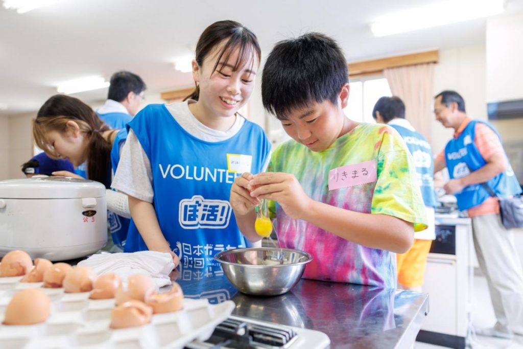 子ども食堂で一緒に調理をする学生と子どもたち