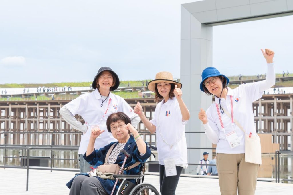 車いすユーザーをサポートするLET’S EXPOの会場内サポートボランティアと車いすユーザーの女性
