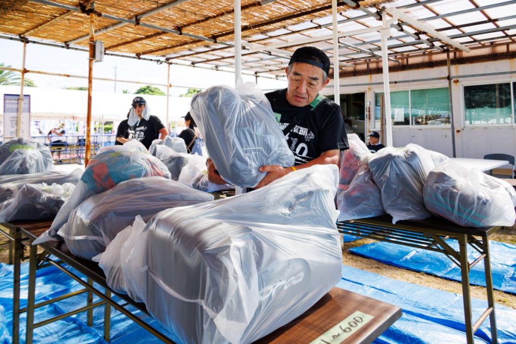 ランナーから預かった荷物を整理するマラソンボランティア