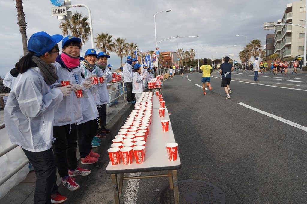 給水ポイントでコップを並べ、ランナーを応援するマラソンボランティア