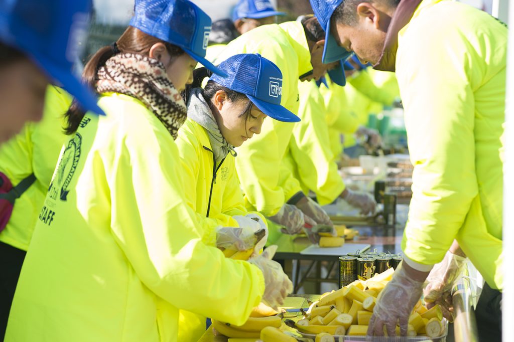 給食ポイントで配布するバナナを準備するマラソンボランティア