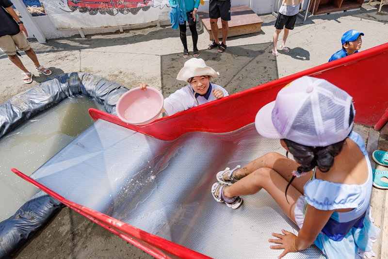 子どもと滑り台で遊んでいる様子