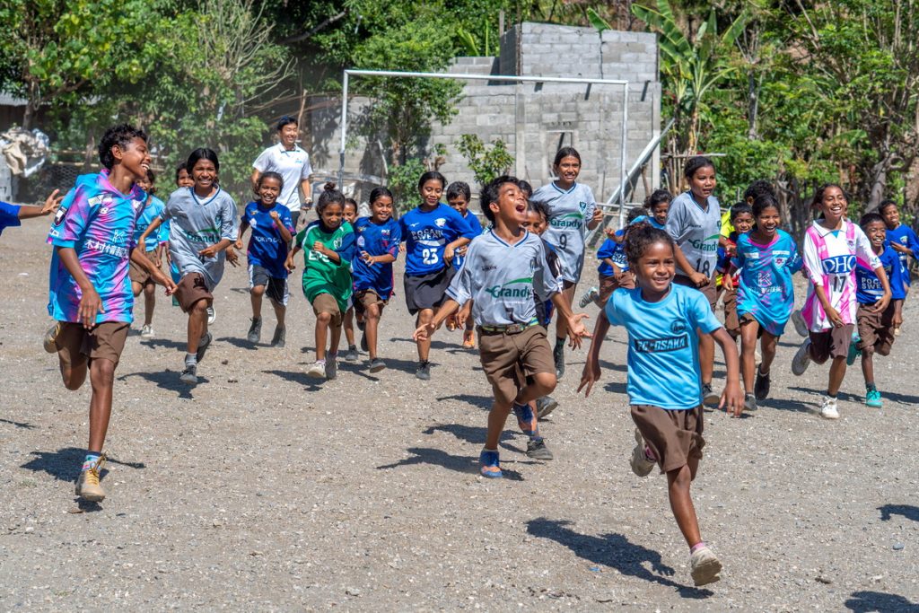Jリーグクラブから寄付を受けたユニフォームを着てサッカー教室に参加する東ティモールの子どもたち
