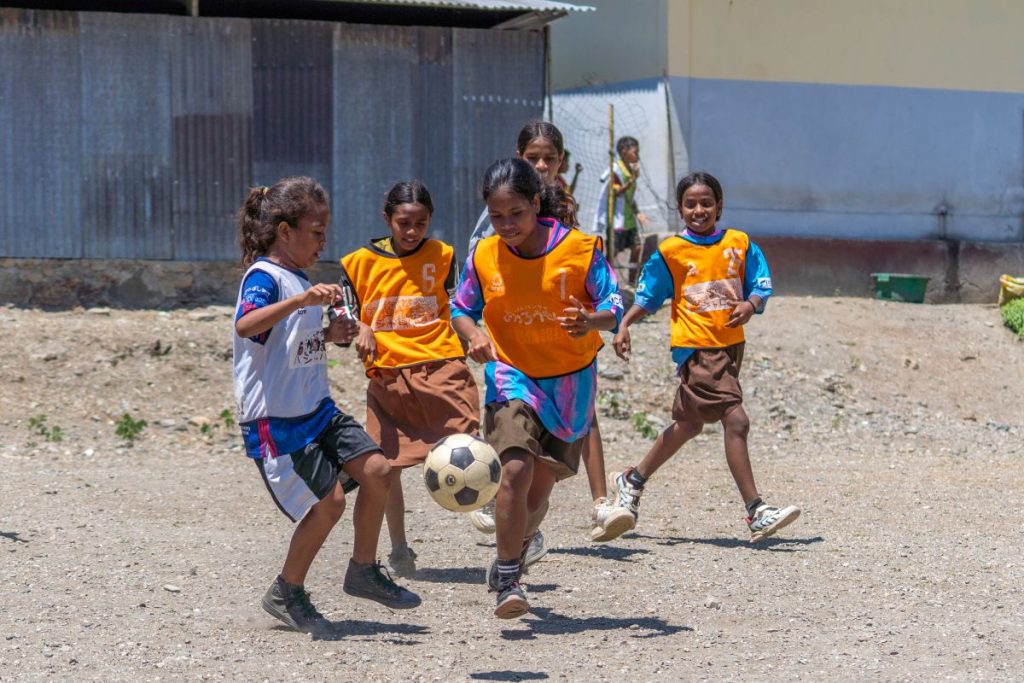 ギラヴァンツ北九州から寄付を受けたビブスを着てサッカーの練習する東ティモールの少女たち