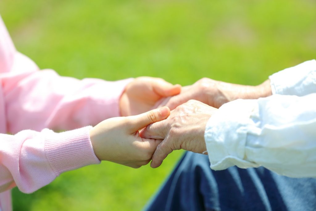若者と高齢者が手を取る描写