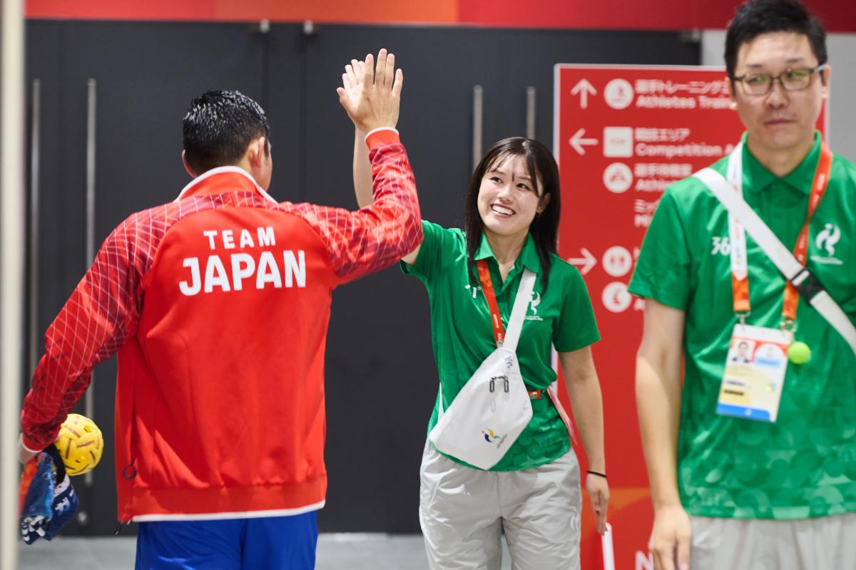 セパタクロー日本代表選手とハイタッチするボランティア
